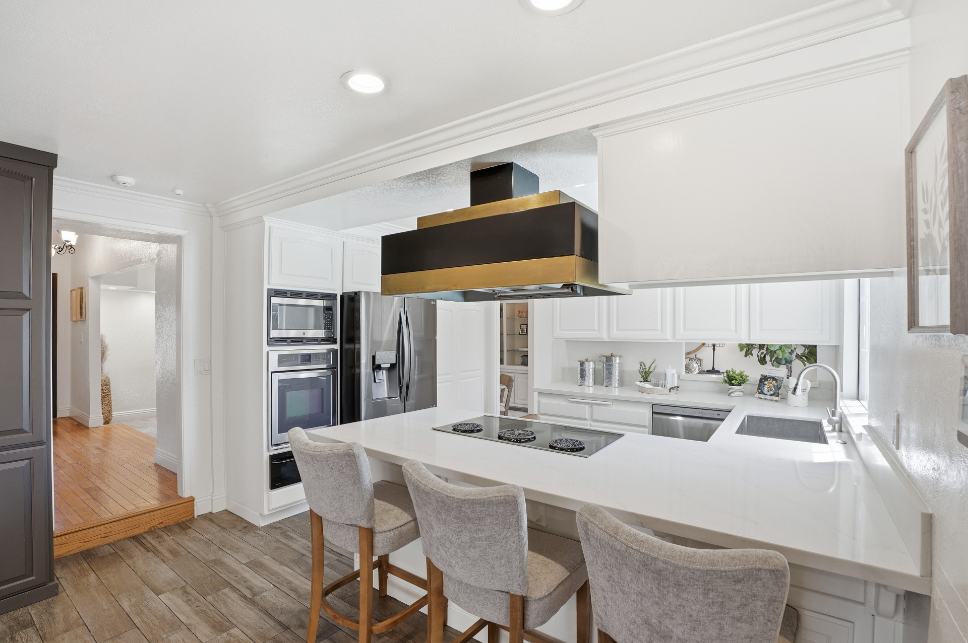 Bright kitchen with white cabinetry and statement range hood